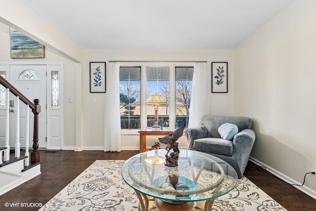 living area with wood finished floors, baseboards, and stairs