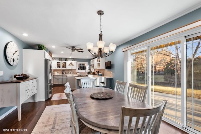 dining space with recessed lighting, dark wood-style flooring, and a notable chandelier