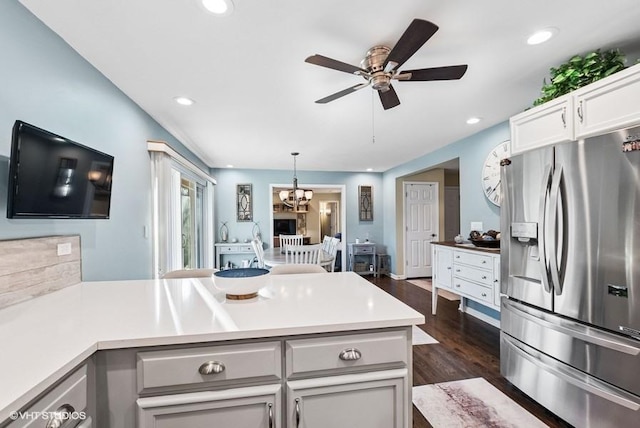 kitchen featuring a peninsula, stainless steel refrigerator with ice dispenser, dark wood finished floors, and recessed lighting