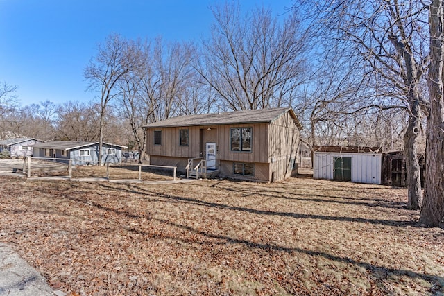 view of front of house with entry steps, fence, an outdoor structure, and a storage unit