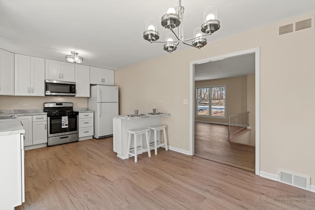 kitchen featuring a chandelier, stainless steel appliances, light countertops, and visible vents