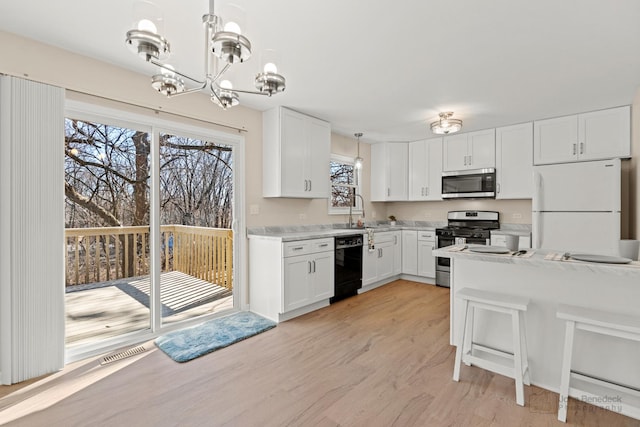 kitchen featuring visible vents, white cabinets, light wood-style flooring, appliances with stainless steel finishes, and light countertops