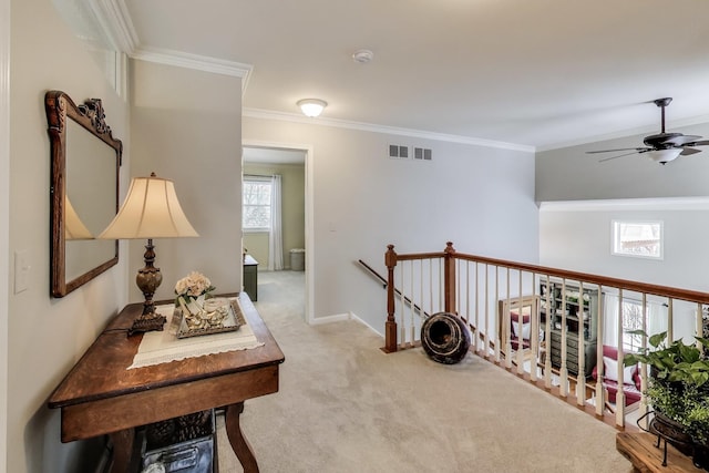 hall with light carpet, visible vents, an upstairs landing, and crown molding