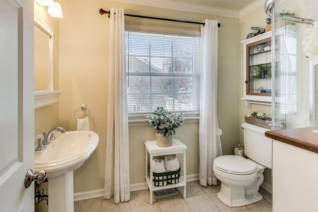 bathroom featuring baseboards, tile patterned floors, toilet, and crown molding