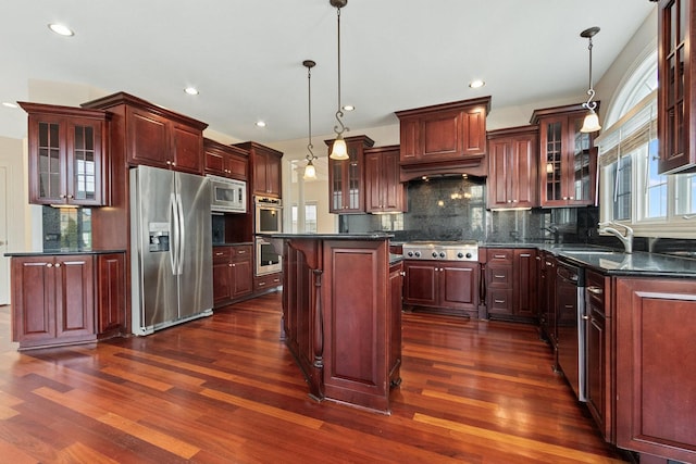 kitchen featuring dark wood-style floors, tasteful backsplash, stainless steel appliances, and a sink