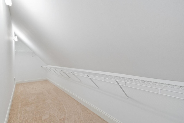 spacious closet with light carpet and lofted ceiling