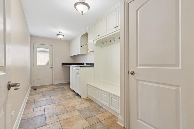 mudroom with stone finish floor and baseboards