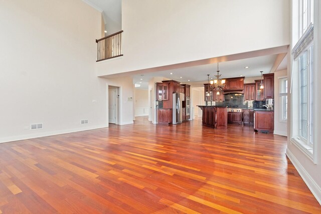 kitchen featuring stainless steel appliances, dark wood-type flooring, backsplash, dark countertops, and glass insert cabinets