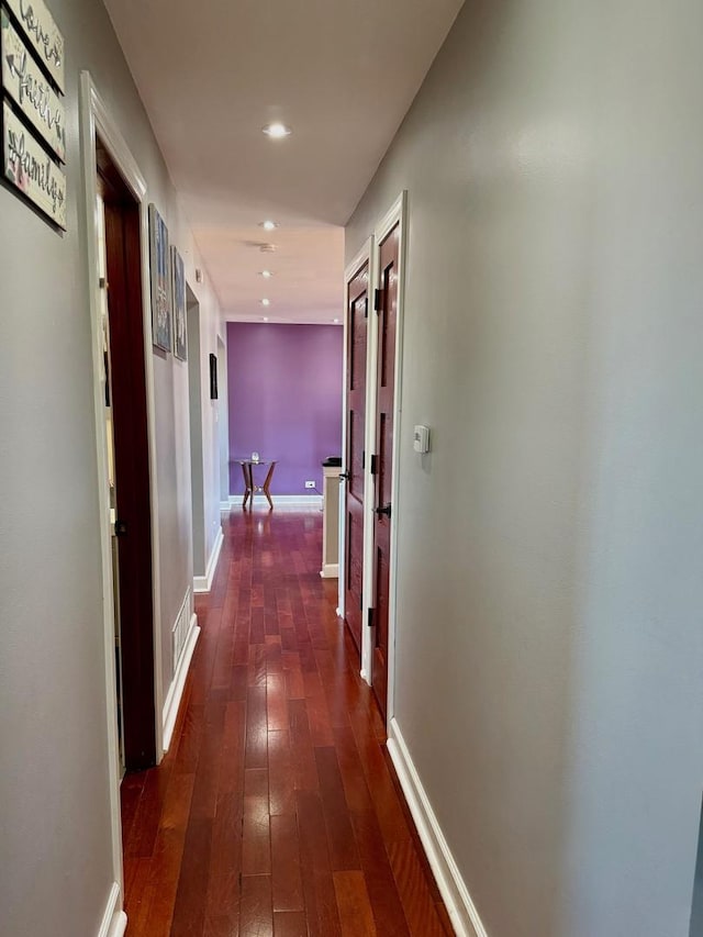 hall with recessed lighting, dark wood finished floors, and baseboards