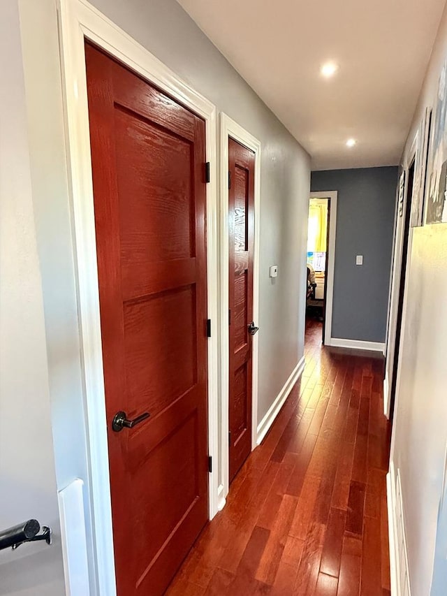 corridor featuring baseboards, dark wood-type flooring, and recessed lighting