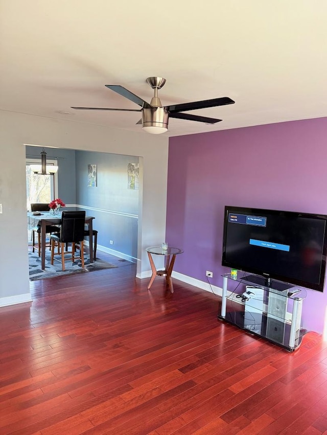 living area with ceiling fan, baseboards, and wood finished floors