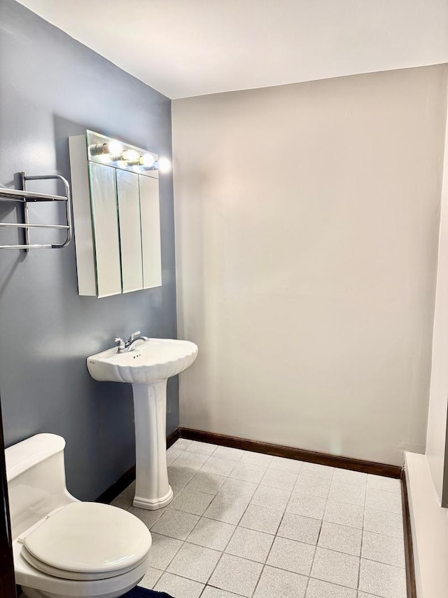 bathroom with toilet and baseboards