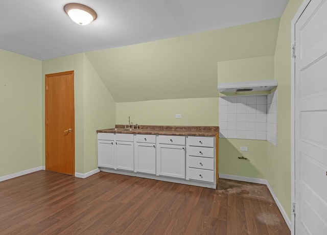 interior space with lofted ceiling, a sink, baseboards, and wood finished floors