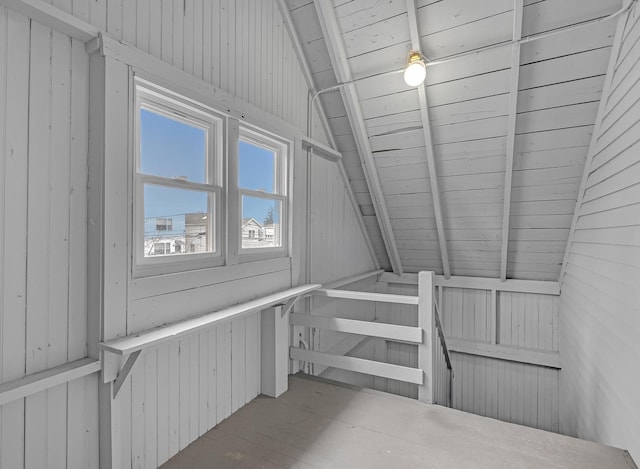 stairway with vaulted ceiling with beams, wood walls, and wooden ceiling