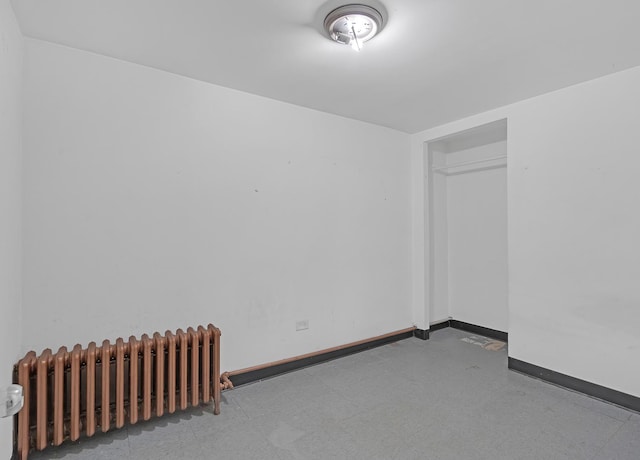 empty room with baseboards and radiator