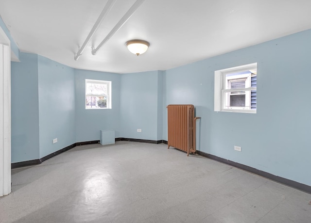 empty room featuring radiator heating unit and baseboards