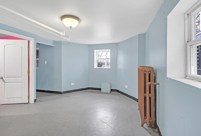 empty room featuring radiator heating unit and baseboards