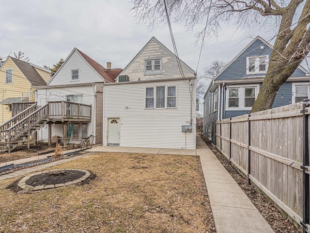 back of property featuring stairway, fence, a deck, and a patio