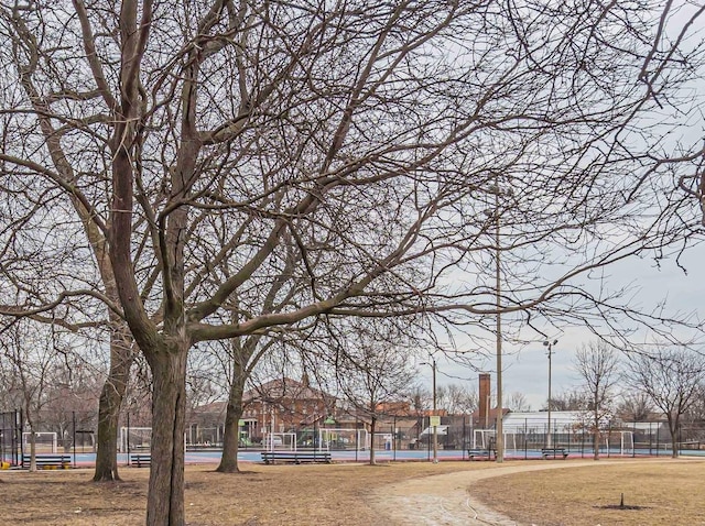 surrounding community featuring a tennis court and fence