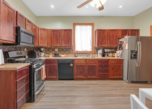 kitchen with tasteful backsplash, light wood-style flooring, stainless steel appliances, light countertops, and a sink