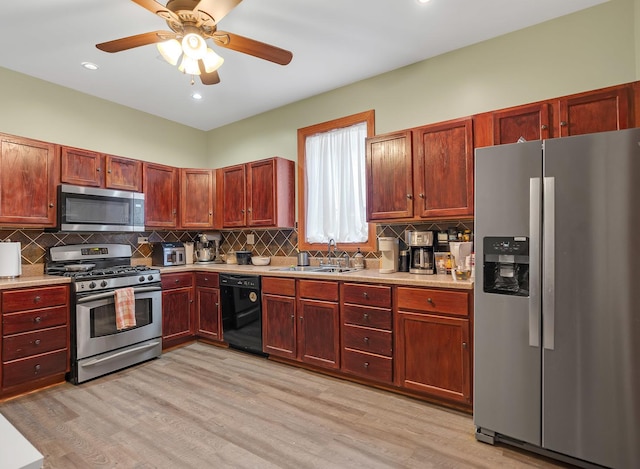 kitchen with stainless steel appliances, light wood-type flooring, a sink, and light countertops