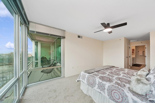 carpeted bedroom with access to outside, visible vents, and a ceiling fan