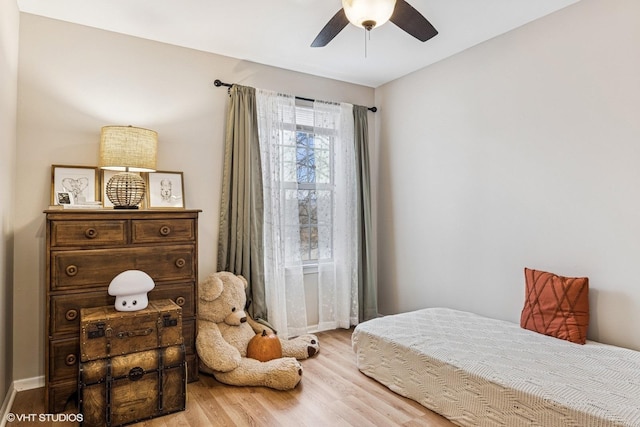 bedroom with wood finished floors, a ceiling fan, and baseboards