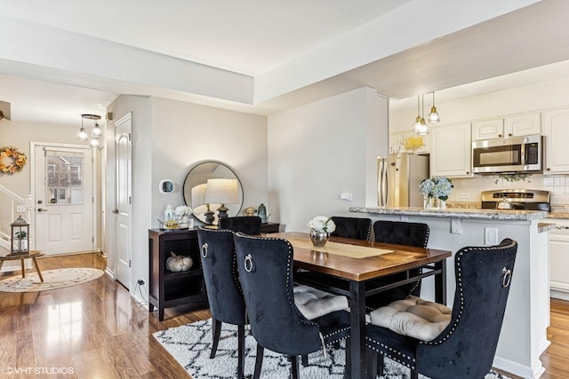 dining space with wood finished floors