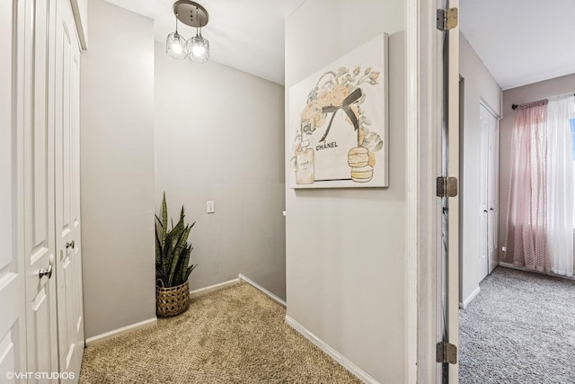 hall featuring carpet floors and baseboards