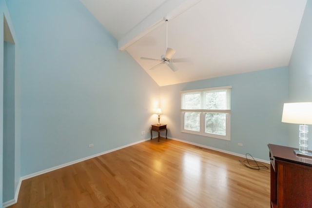 spare room with light wood-type flooring, ceiling fan, baseboards, and beam ceiling