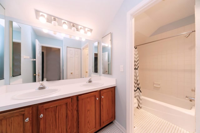 full bathroom featuring double vanity, shower / bath combo with shower curtain, a sink, and tile patterned floors