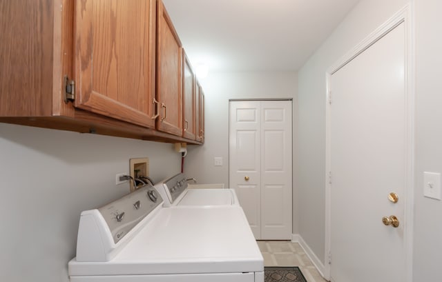 clothes washing area with cabinet space, baseboards, and separate washer and dryer