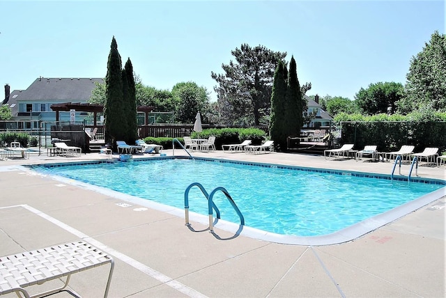 community pool with a patio and fence