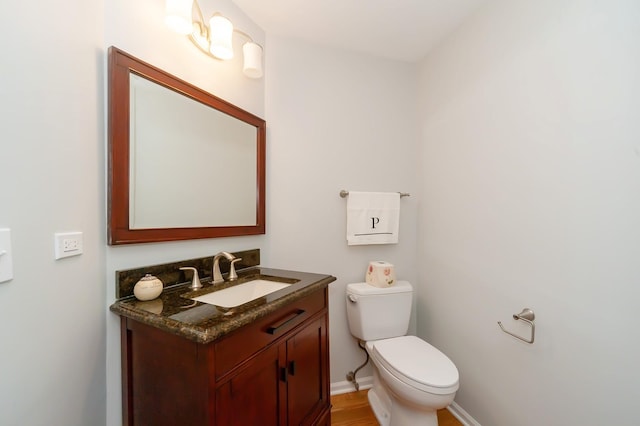 bathroom with baseboards, vanity, and toilet