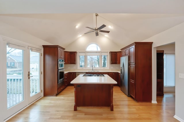 kitchen featuring a sink, light wood-style floors, stainless steel appliances, and light countertops