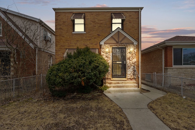 view of front of home with stone siding, brick siding, and fence