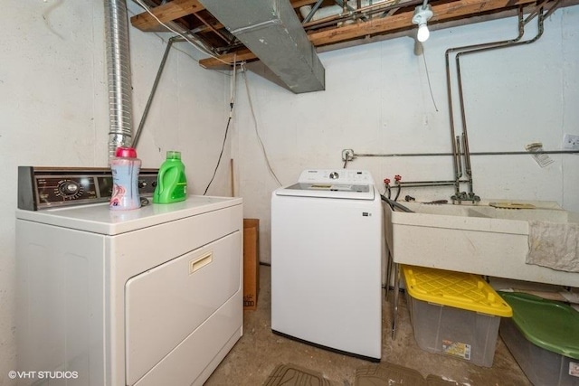 clothes washing area featuring laundry area and washer and clothes dryer