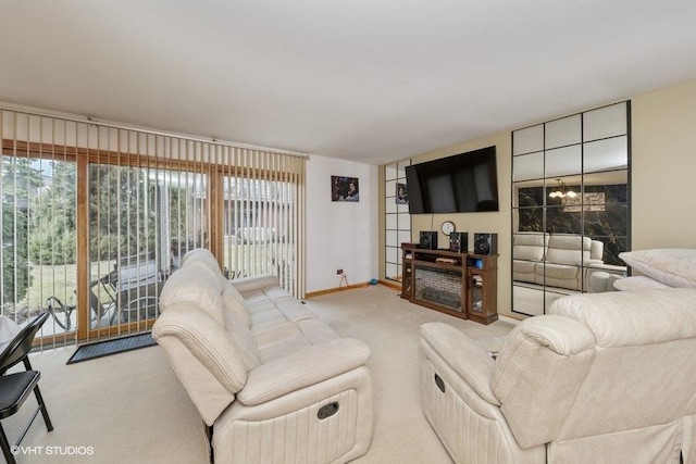 living room with a chandelier, carpet, a wealth of natural light, and baseboards