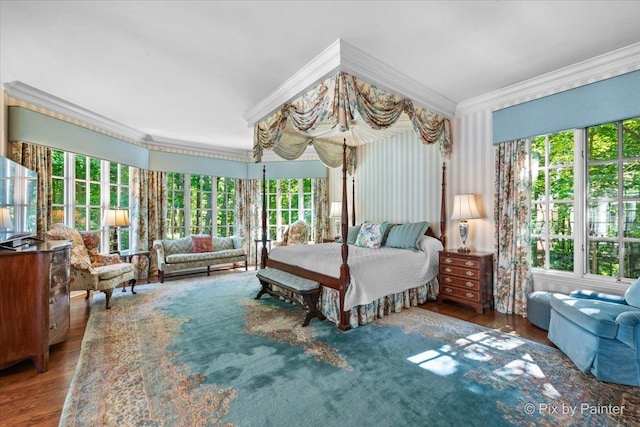 bedroom with ornamental molding and wood finished floors