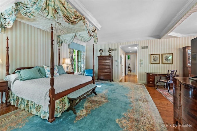 bedroom featuring wallpapered walls, crown molding, baseboards, and wood finished floors