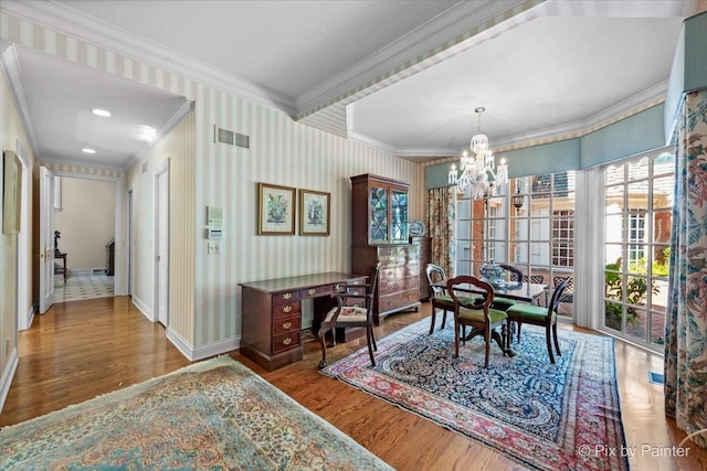 interior space featuring wallpapered walls, a notable chandelier, crown molding, and wood finished floors