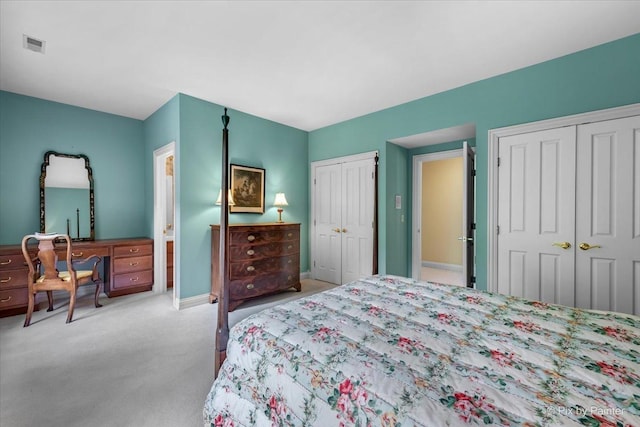 bedroom with multiple closets, carpet flooring, visible vents, and baseboards