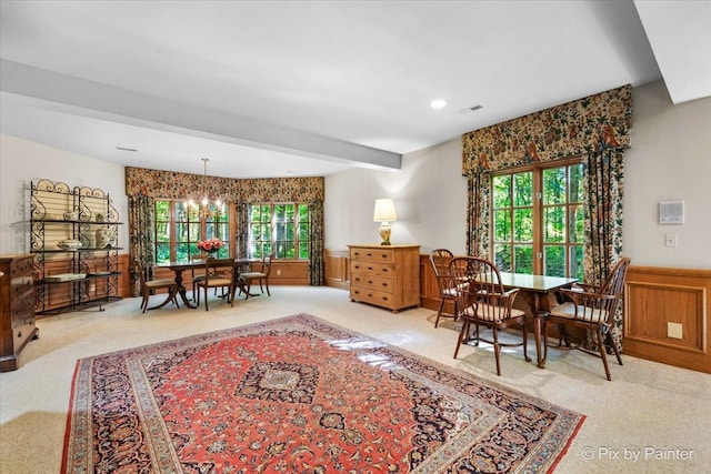 sitting room featuring visible vents, wainscoting, carpet flooring, a chandelier, and beamed ceiling