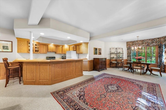 kitchen with beam ceiling, light colored carpet, glass insert cabinets, freestanding refrigerator, and a peninsula