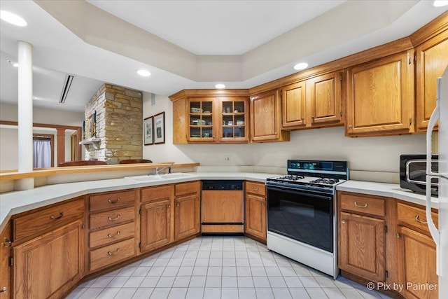 kitchen featuring paneled dishwasher, range with gas stovetop, brown cabinets, and a sink