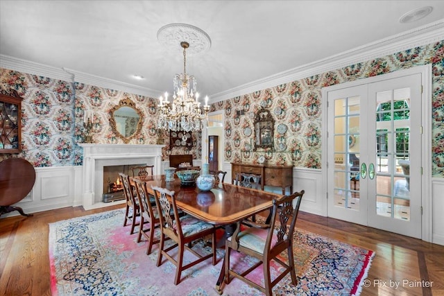 dining space featuring a wainscoted wall, french doors, a high end fireplace, and wallpapered walls