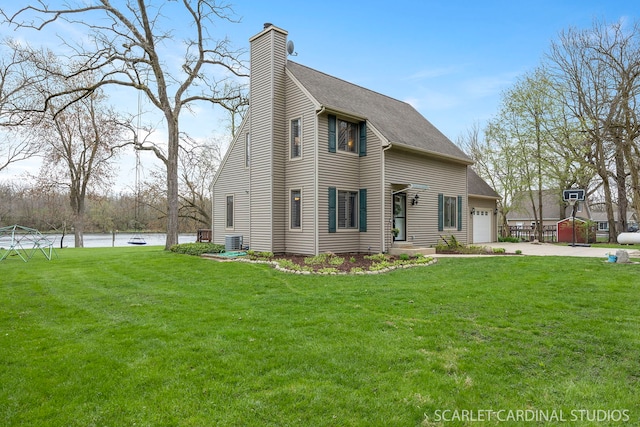 view of front of home featuring a chimney, a front lawn, a water view, an attached garage, and driveway