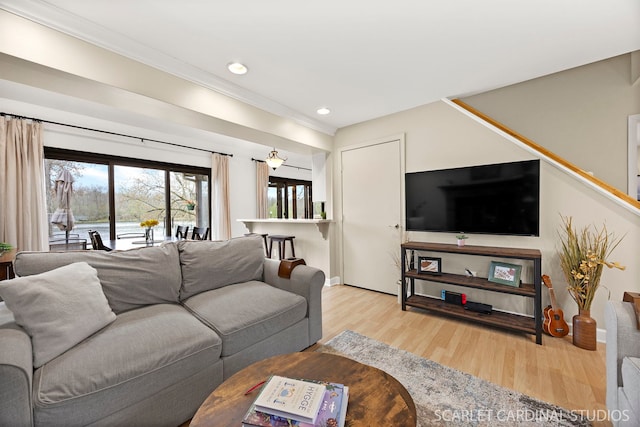 living room featuring wood finished floors, recessed lighting, and crown molding