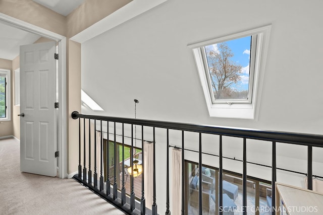 corridor with carpet flooring, a skylight, and baseboards