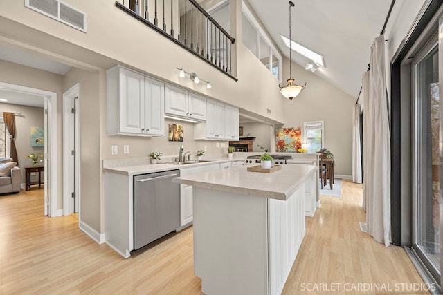 kitchen featuring light countertops, dishwasher, visible vents, and light wood-style flooring